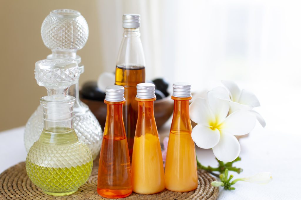 "Several bottles of homemade summer perfume lying on a table"

