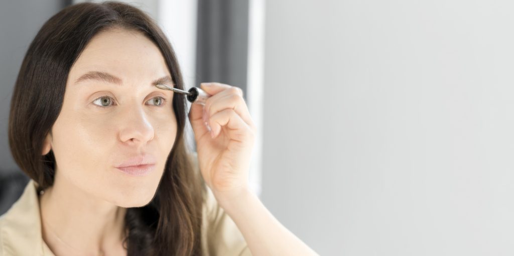 Woman brushing her eyebrows to stimulate growth