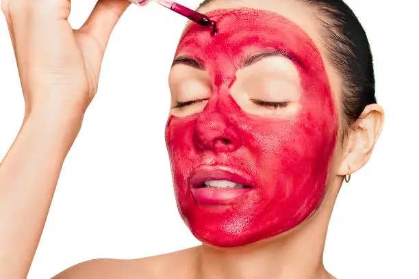 Woman applying beetroot face mask for glowing skin - natural DIY skincare