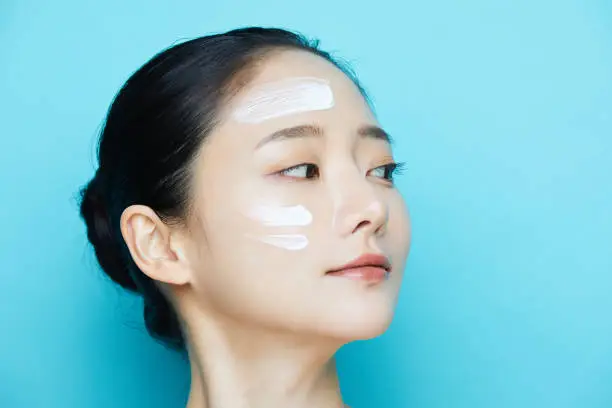 Woman applying skincare during monsoon skincare for glowing skin