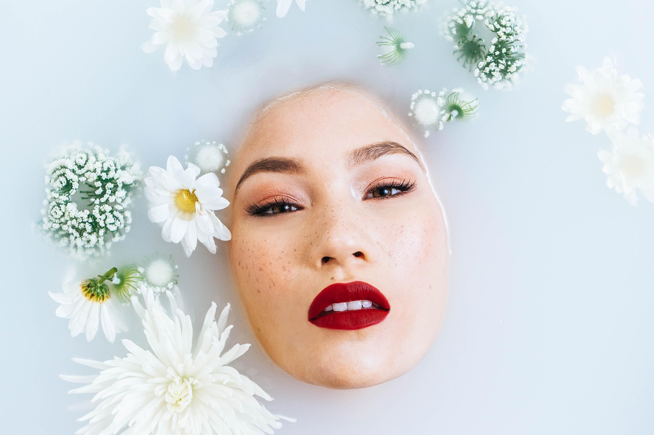 Woman applying skincare in monsoon season with fresh glowing skin and raindrops in the background